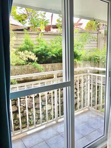 a sliding glass door looking out onto a balcony at Fully equipped Studio unit near Mactan Airport with WIFI, Pool & Gym Access in Mactan