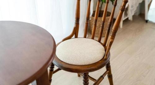 a wooden chair sitting next to a table at Gallery Pension in Taean