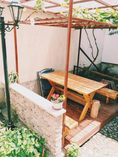 a wooden picnic table under a pergola at Guest house Nizama's Place in Sarajevo