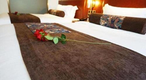 a red rose on a bed in a hotel room at James Joyce Coffetel Beijing Yizhuang Rongjing East Street Subway Station in Beijing