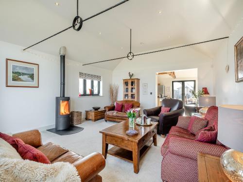 a living room with couches and a fireplace at Archie's Barn in Lenwade