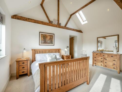 a bedroom with a wooden bed and a sink at Archie's Barn in Lenwade