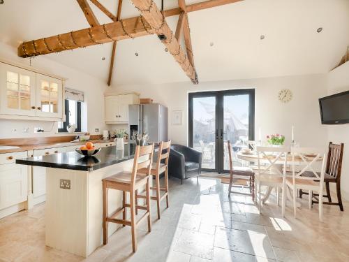 a kitchen and dining room with a table and chairs at Archie's Barn in Lenwade