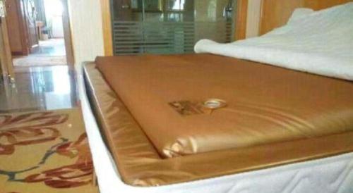 a close up of a bed in a room at Vienna Classic Hotel Qingdao Huangdao in Huangdao