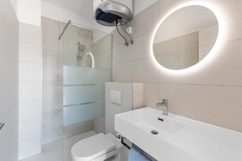 a bathroom with a toilet and a sink and a mirror at MT SUN 115 App 1 in Selce