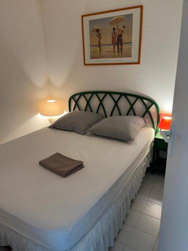 - un lit blanc avec une serviette dans l'établissement Location appartement au Cap d'Agde, au Cap d'Agde