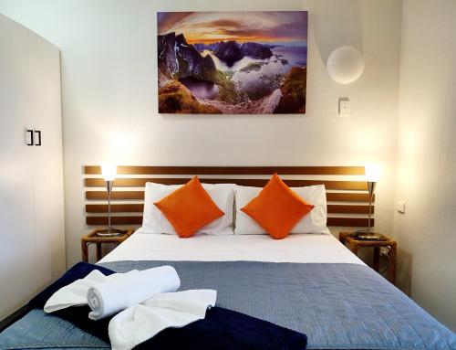 a bedroom with a bed with orange and blue pillows at Oceanside Hawks Nest in Hawks Nest
