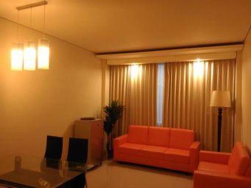 a living room with a couch and a glass table at Kharisma Hotel in Madiun