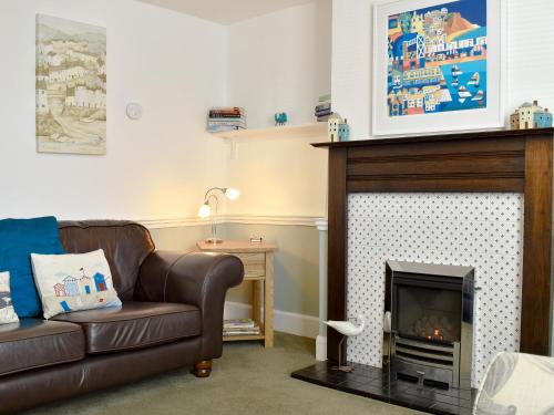 ein Wohnzimmer mit Couch und Kamin in der Unterkunft Old Town Cottage in Sidmouth
