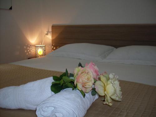 een bed met een handdoek en bloemen erop bij B&B Mare Blu in Gallipoli
