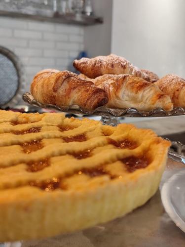 a table with a pie and other pastries on pans at Bell Suite Hotel in Bellaria-Igea Marina