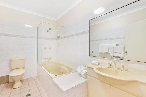 利斯莫爾的住宿－舒適先得汽車旅館，带浴缸、盥洗盆和卫生间的浴室