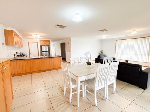 a kitchen and living room with a table and chairs at 4 Pinnacle Place in North Wagga