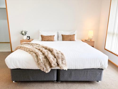 a bedroom with a large bed with a blanket on it at 4 Pinnacle Place in North Wagga