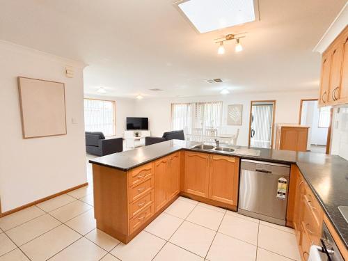 an open kitchen with a sink and a living room at 4 Pinnacle Place in North Wagga