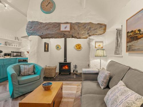 Una sala de estar con un sofá y una chimenea. en Garth Yr Hebog, en Porthmadog