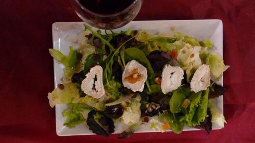 a white plate topped with a salad on top of a table at Hotel rural Puerta de Monfragüe in Villarreal de San Carlos