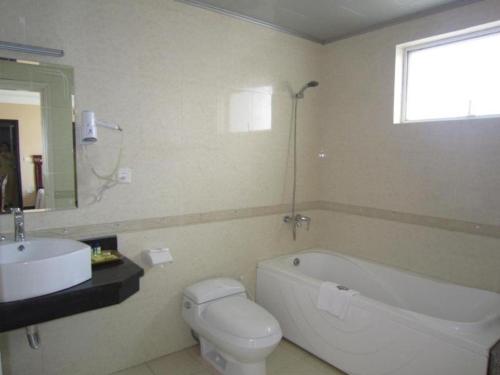 une salle de bain avec un lavabo, une baignoire et des toilettes dans l'établissement Classic Hoang Long Hotel, à Hai Phong