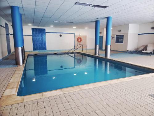 - une piscine dans un bâtiment aux colonnes bleues dans l'établissement Studio Le Panoramic les Balcons d'Aix, à La Féclaz