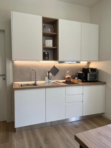 a kitchen with white cabinets and a sink at Appartamento San Marco in Reggio Calabria