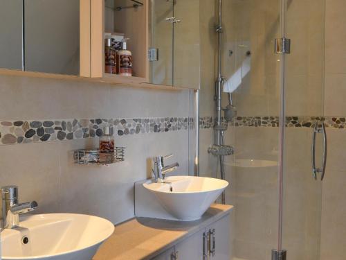 a bathroom with two sinks and a shower at River Mill House in Ballachulish