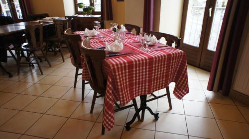 einem Tisch mit einem roten und weißen karierten Tischtuch in der Unterkunft Auberge De Raulhac in Raulhac