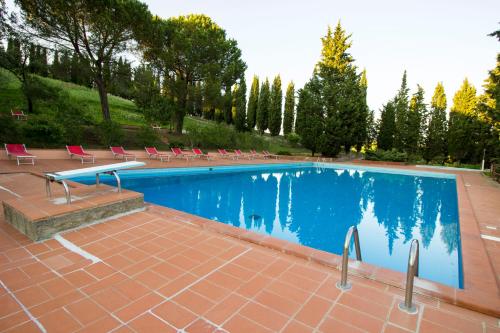 a large swimming pool with chairs and a table at Borgo Il Poggio Agriturismo in Montaione