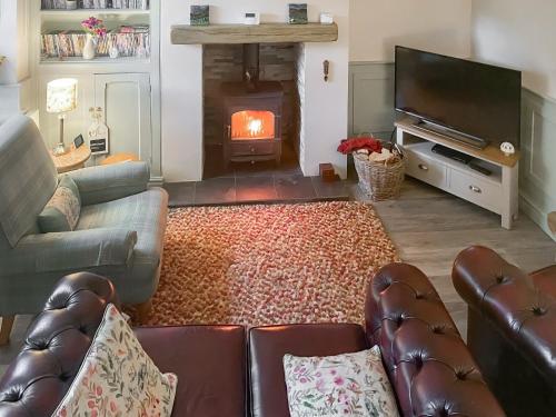 a living room with a couch and a fire place at 1 Bronrallt in Penmaen-mawr
