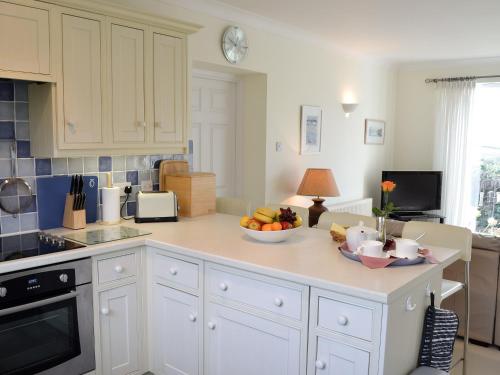 a kitchen with a bowl of fruit on a counter at Moonrakers in Ruan Lanihorne