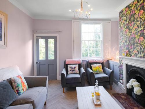 a living room with two chairs and a fireplace at Bliss House in Madeley