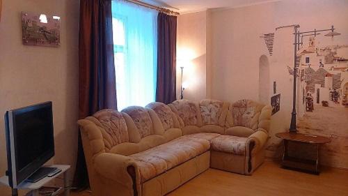 a living room with a couch and a television at Apartment Hokhryakova 21 City Center in Yekaterinburg