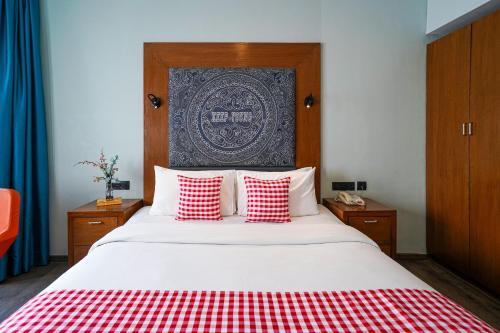 a bedroom with a bed with red and white pillows at Open Hotel by Olive - The Infantry Hotel in Bangalore