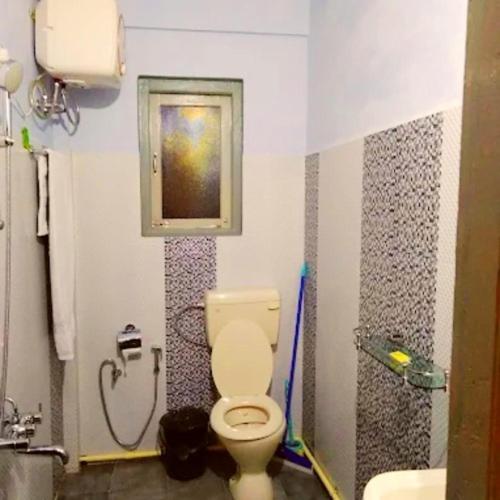 un baño con inodoro y lavabo en Mension Inn, en Cherrapunji