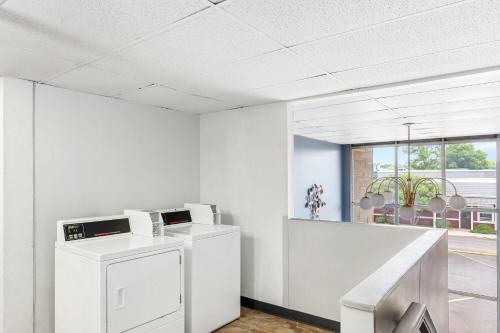 an office with a washer and dryer in a room at Travelodge by Wyndham Bloomington in Bloomington