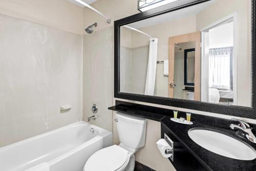a bathroom with a sink and a toilet and a mirror at Days Inn by Wyndham Chattanooga/Hamilton Place in Chattanooga