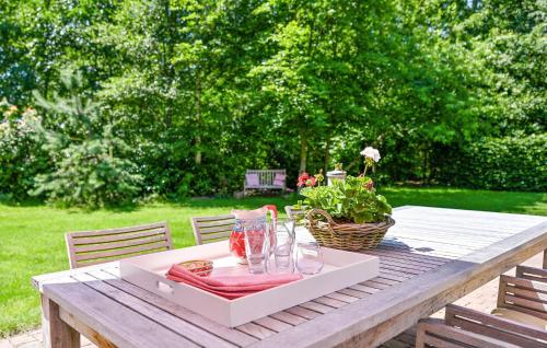 a table with a tray with glasses and a basket of flowers at Buitengoed Het Lageveld - 52 in Hoge-Hexel