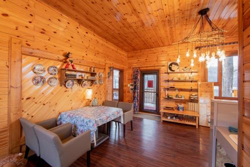 a dining room with a table and chairs and wooden walls at Yabuli QuShe Four seasons Private Lakefornt B&B in Xinhua