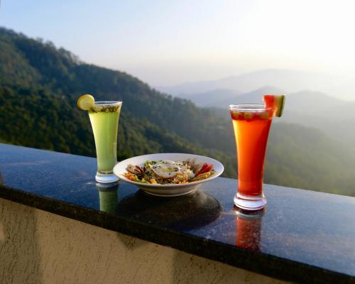a table with a bowl of food and two drinks at Hotel Cloud End Lansdowne in Lansdowne