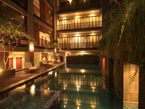a swimming pool in front of a building at night at D'Anaya Hotel Bogor in Bogor