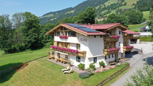 a house in the mountains with flowers at Gästehaus Hofer in Brixen im Thale