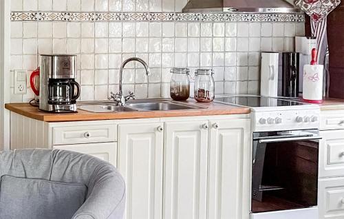 a kitchen with white cabinets and a sink and a stove at Stunning Home In Västervik With Kitchen in Västervik