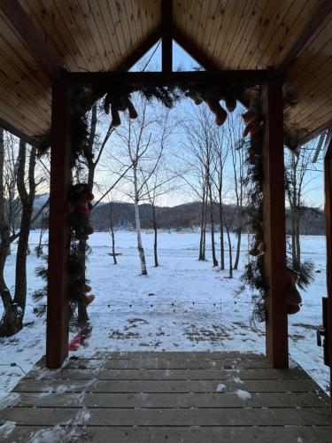 a wooden gazebo with snow on the ground at Yabuli QuShe Four seasons Private Lakefornt B&B in Xinhua