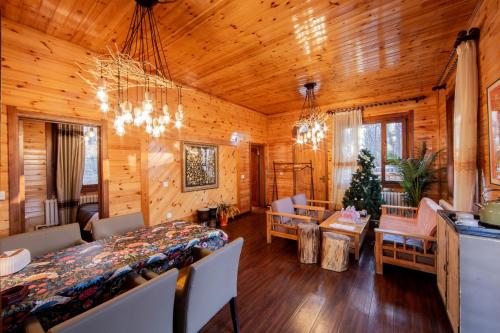 a dining room and living room with a table and chairs at Yabuli QuShe Four seasons Private Lakefornt B&B in Xinhua