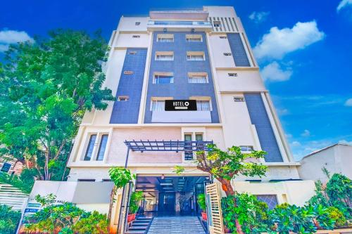 a tall white building with a sign on it at Super Hotel O Grand Governorpet in Vijayawāda