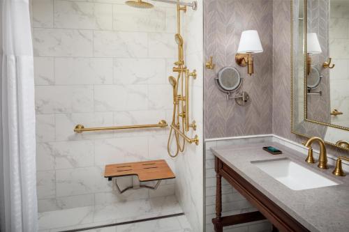 a bathroom with a sink and a shower at The Skirvin Hilton Oklahoma City in Oklahoma City