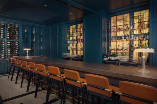 a long bar in a room with chairs at The Skirvin Hilton Oklahoma City in Oklahoma City