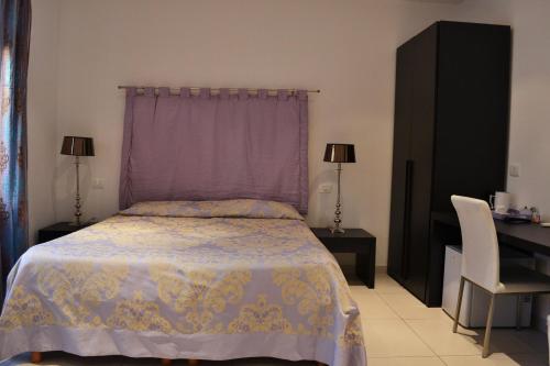 a bedroom with a bed with a purple curtain and a desk at Casa Canale in Reggio Calabria