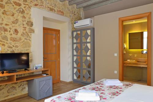 a room with a bed and a television and a bathroom at Elia Kentron in Chania Town