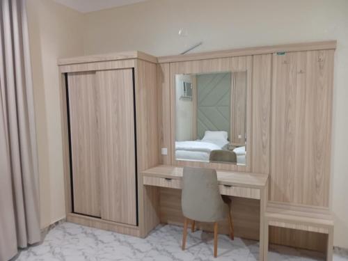 Habitación con escritorio, espejo y cama. en شقق ابراج الخير, en Abha