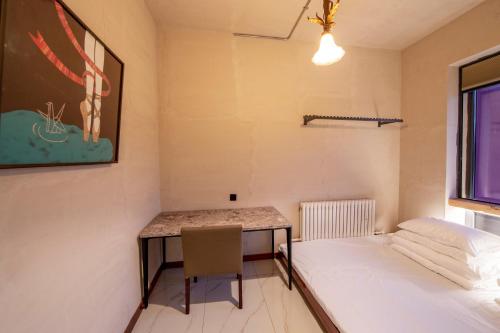 a small room with a bed and a desk at Yabuli QuShe Four seasons Private Lakefornt B&B in Xinhua